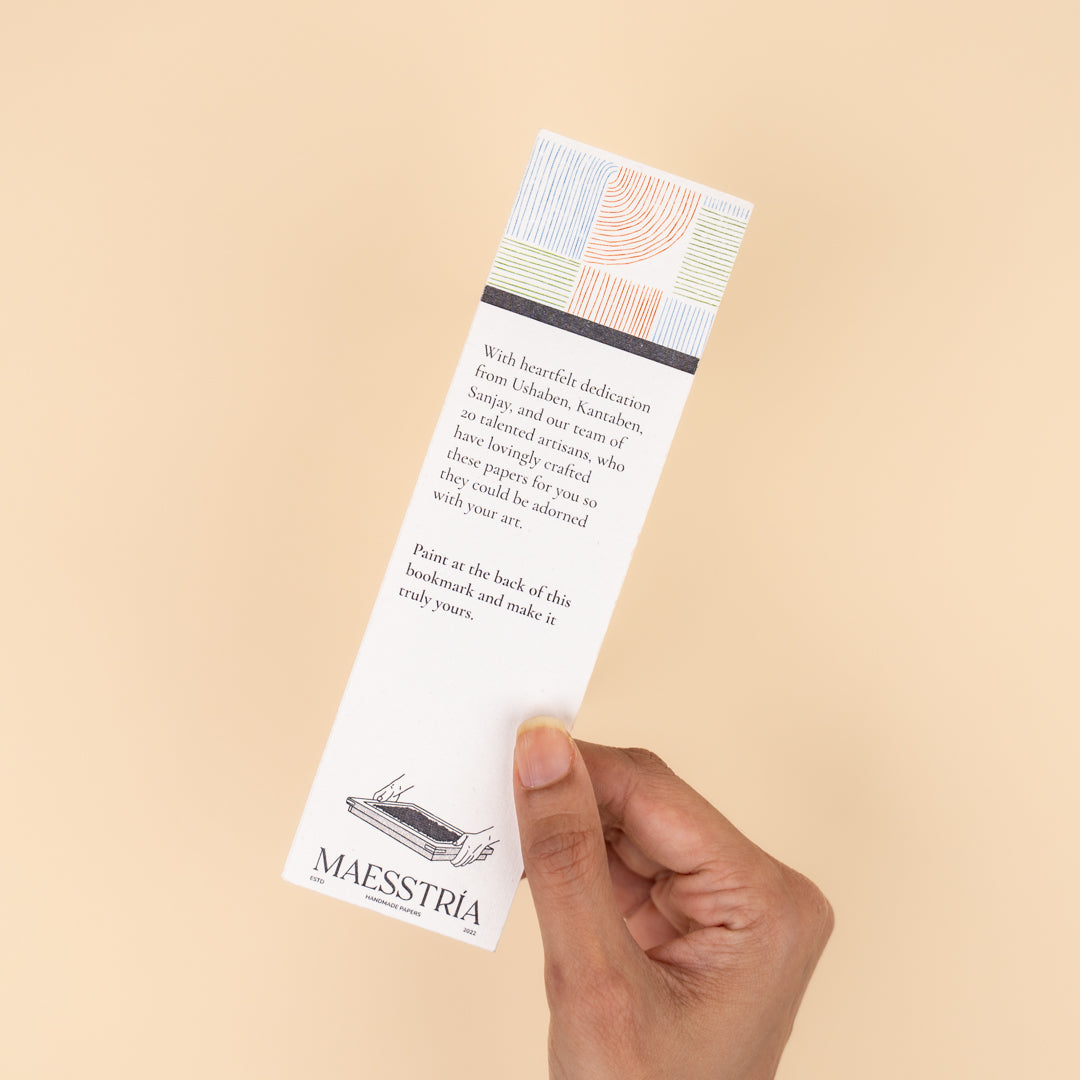 Close-up of a handmade paper bookmark with a gold tassel.